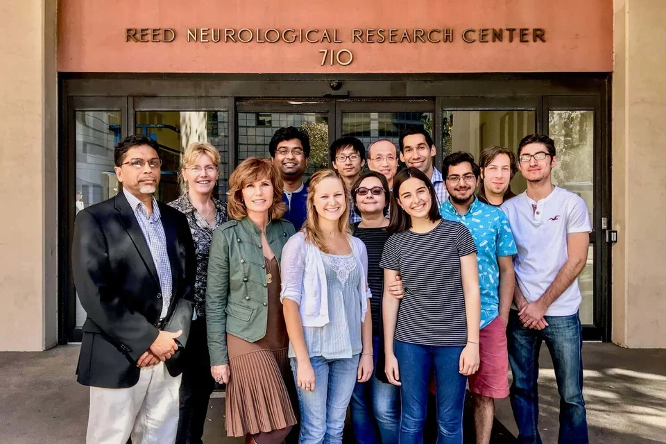 Group of Drug Discovery Lab scientists gathered in front of research center.